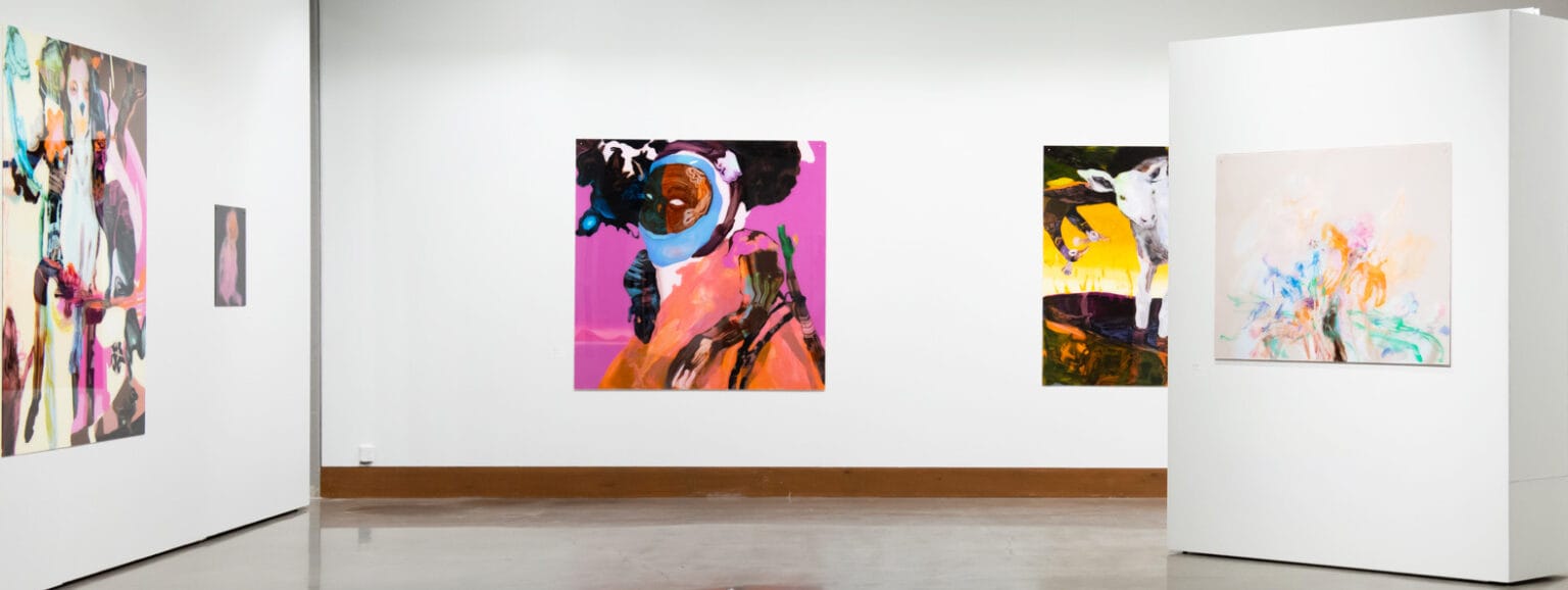 Värikäs taidenäyttely gallerian seinillä.