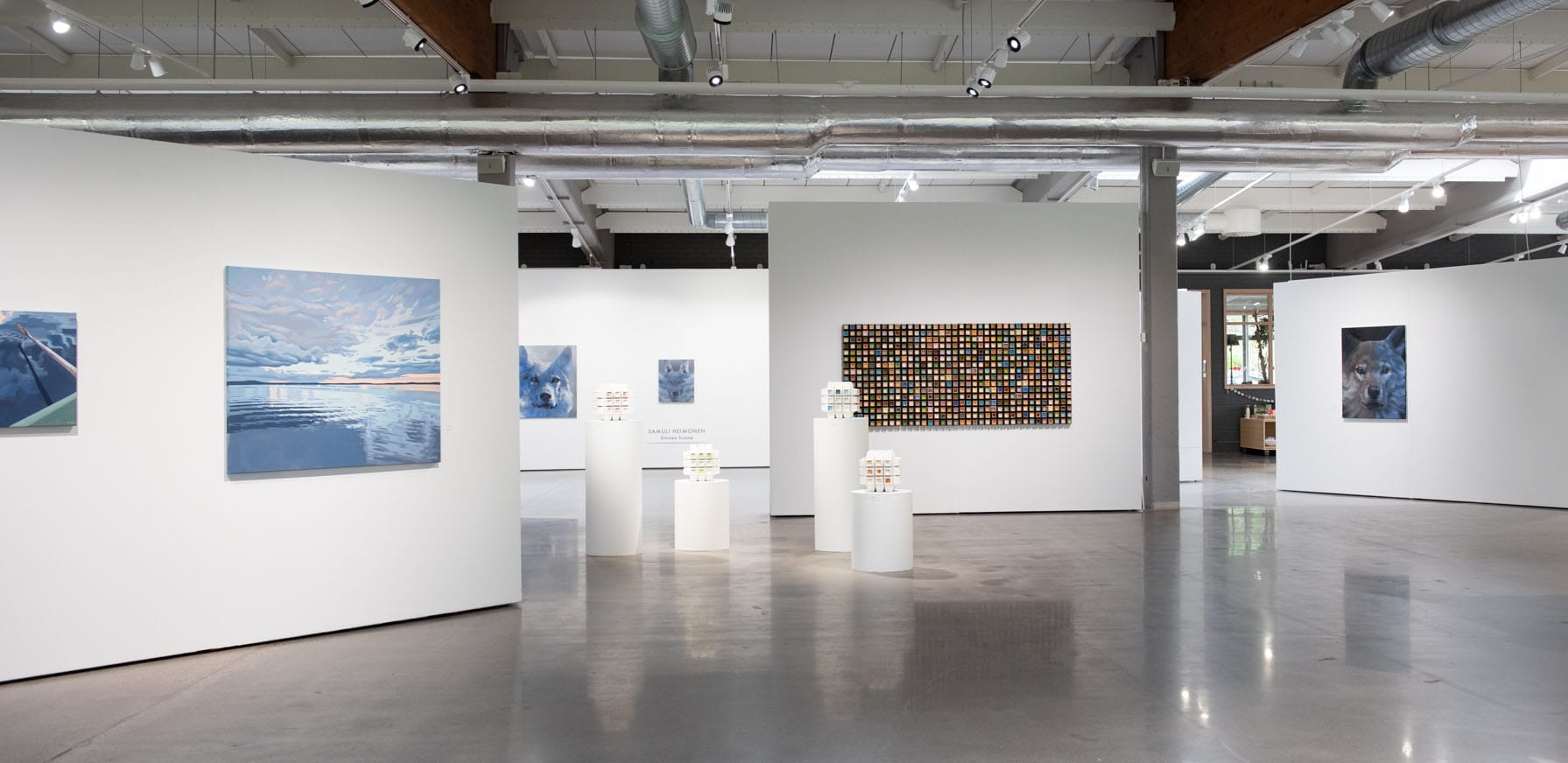 Moderni taidegalleria näyttelytila tauluilla.