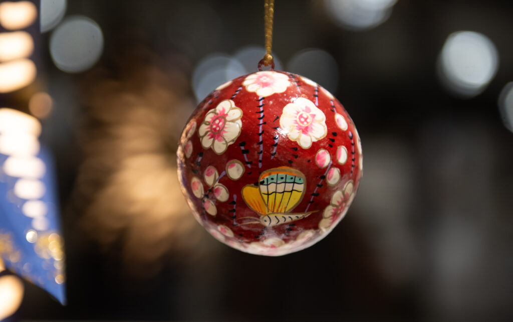 Punainen joulukoriste kukkakuvioilla ja perhosella