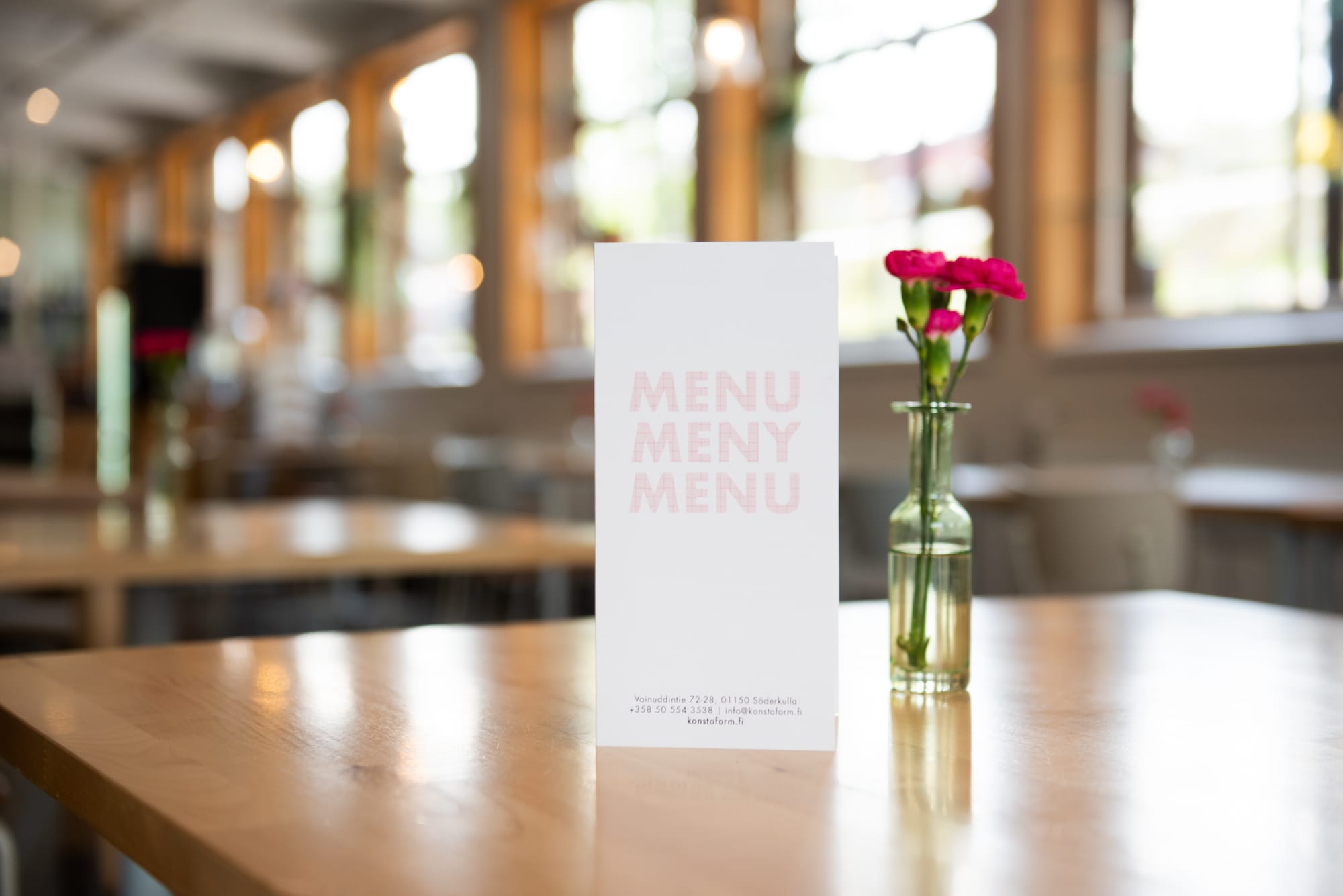 Ravintolan pöytä, menu ja kukkavaasi