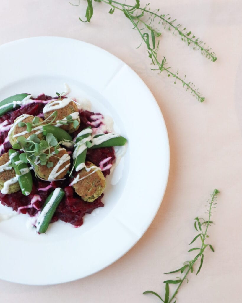 Kasvisruoka-annos lautasella koristekasvien kera