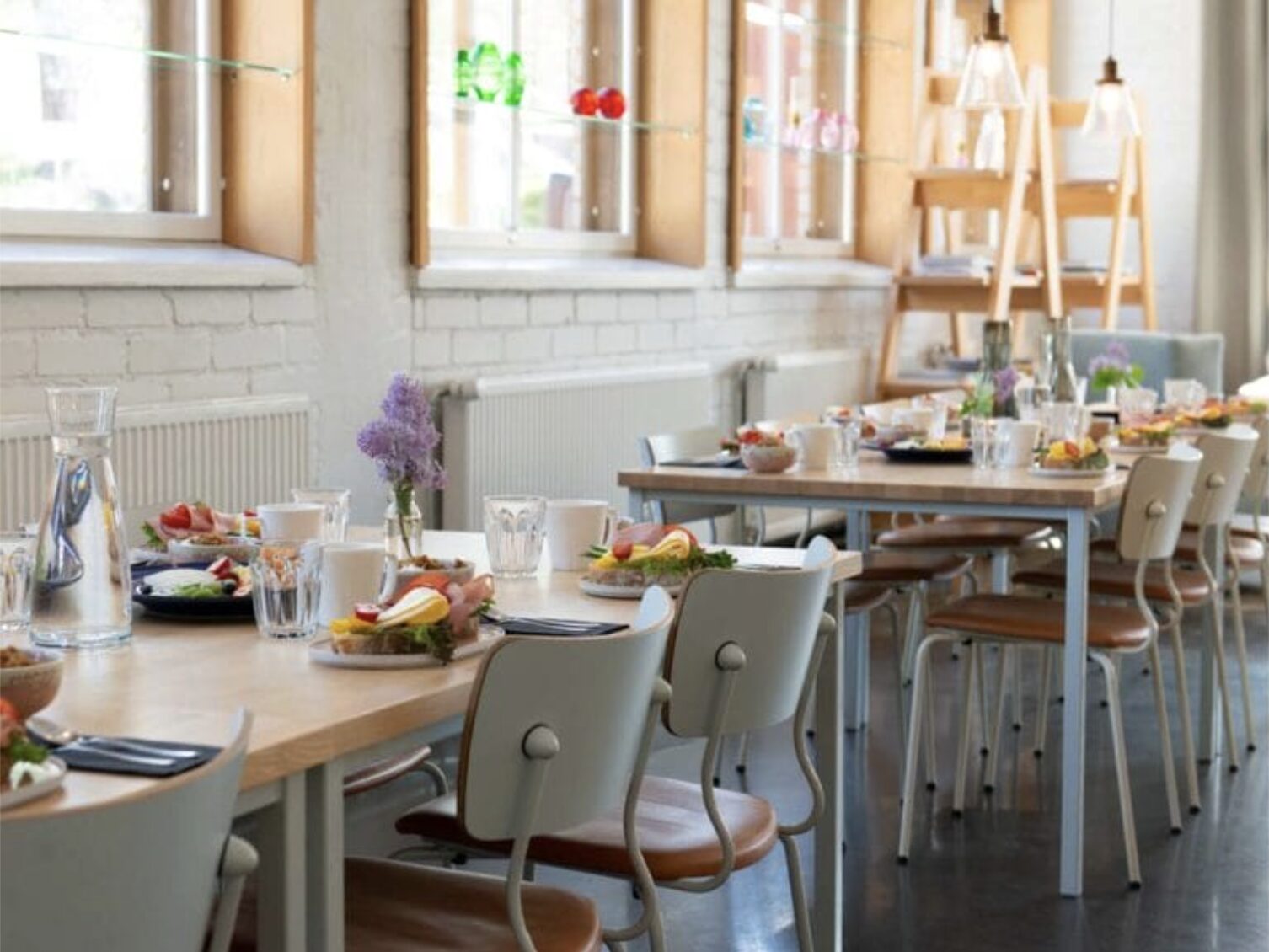 Kahvila täynnä katettuja pöytiä ja tarjoiluastioita.