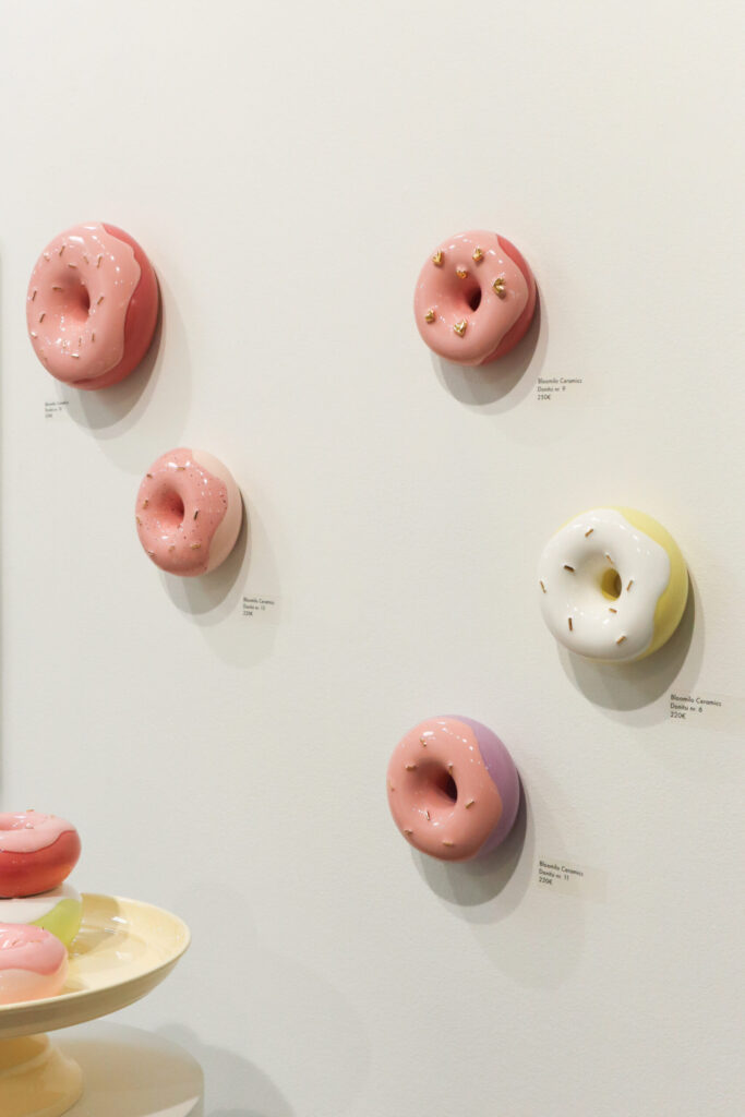 Keraamisia donitseja galleriaseinällä esillä