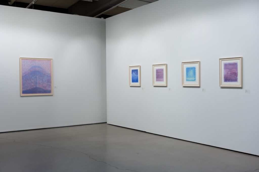 Abstrakteja pastellisävyisiä maalauksia galleriaseinällä