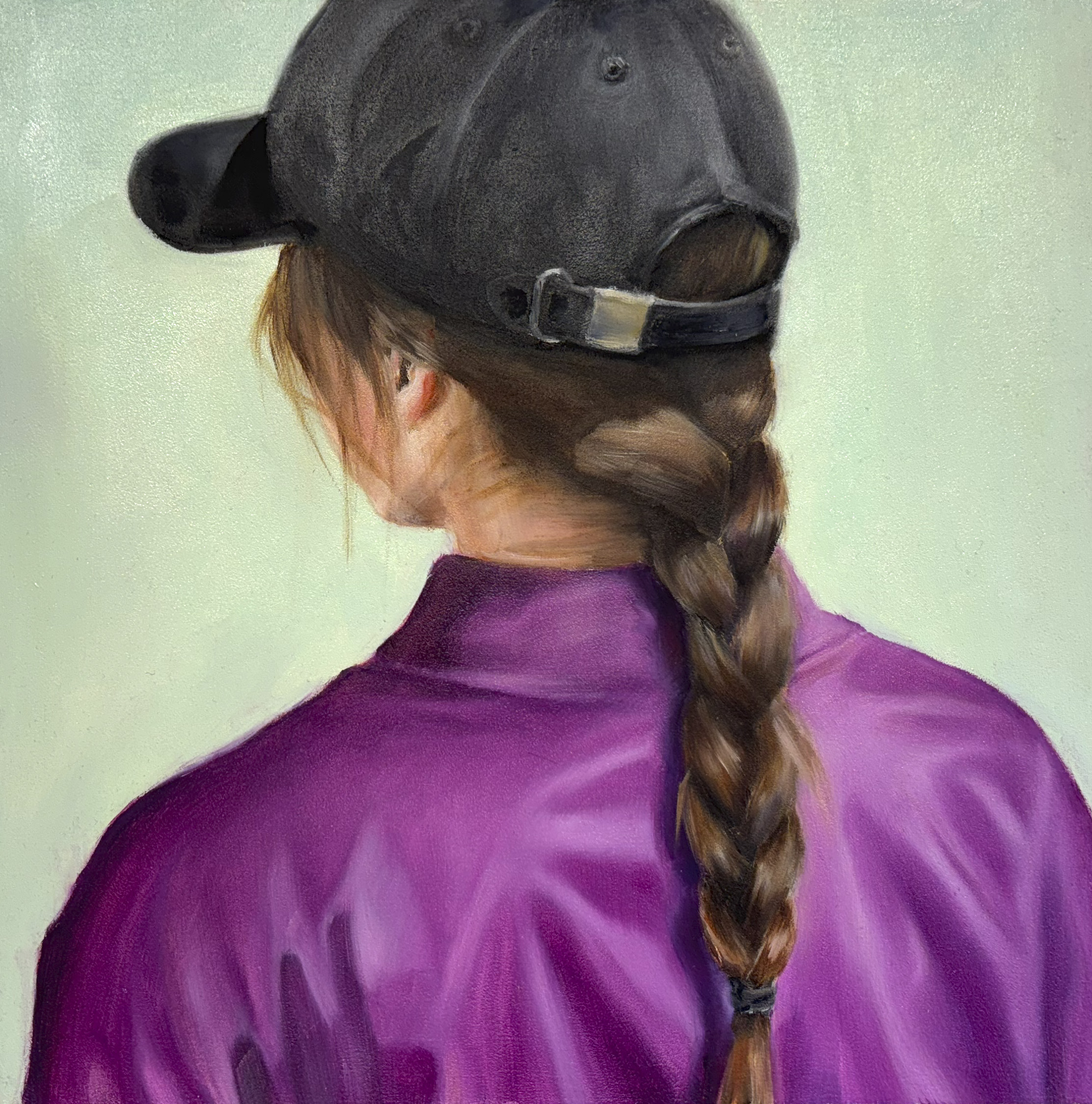 Henkilö violetissa paidassa, lippalakissa