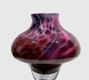 Violetti lasivaasi harmaalla taustalla