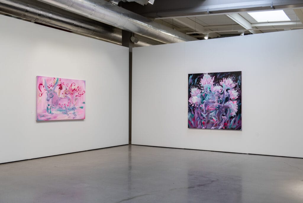 Kaksi taulua galleriassa, vaaleanpunaisia ja violettia värejä.