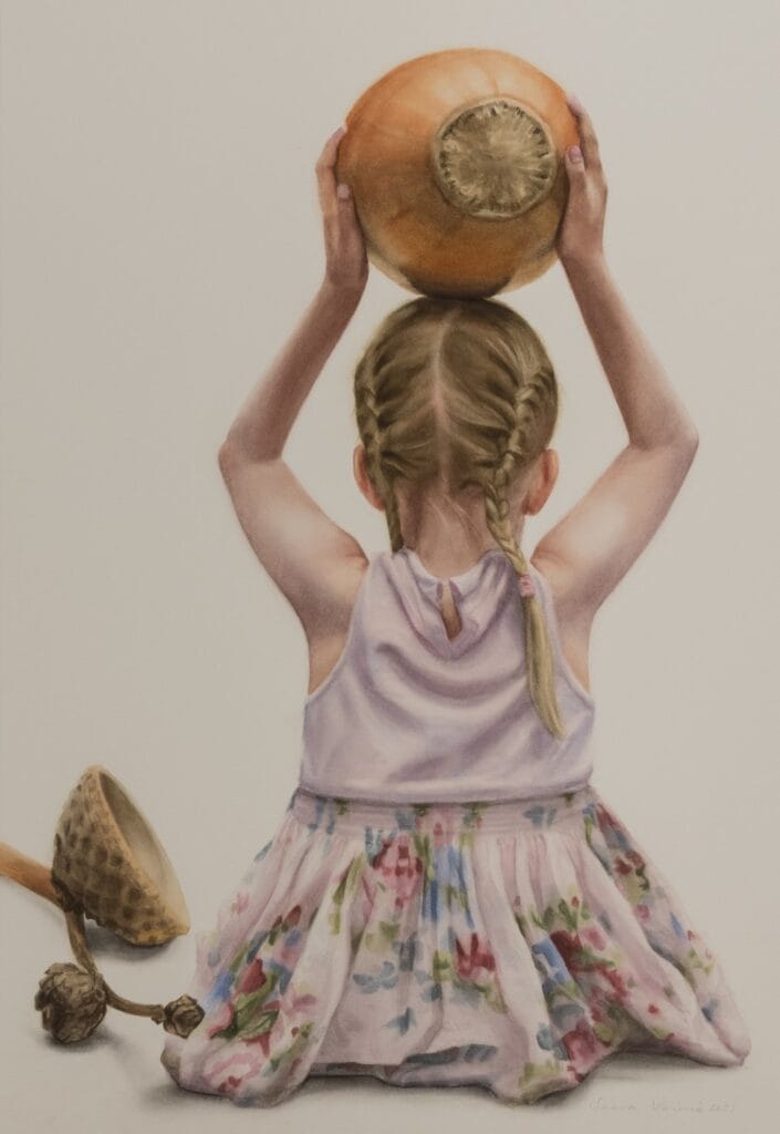 Tyttö mekossa pitää kurpitsaa päänsä päällä