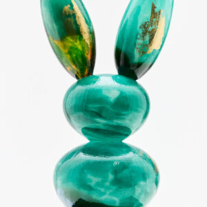 Vihreä lasipupu veistos marmorijalustalla.