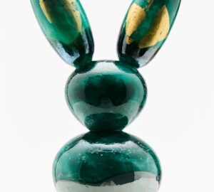 Vihreä pupuveistos kultaisilla yksityiskohdilla