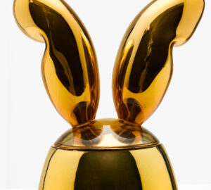 Kultainen jäniksenkorva patsaalla valkoisella taustalla.