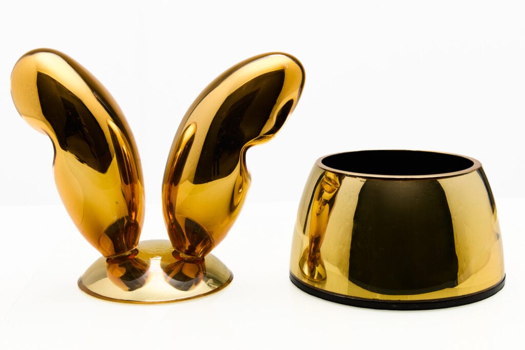 Kultaiset abstraktit koriste-esineet valkoisella taustalla.