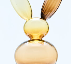 Lasinen pupuveistos marmorijalustalla