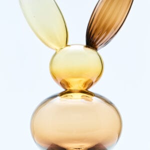 Lasinen pupuveistos marmorijalustalla