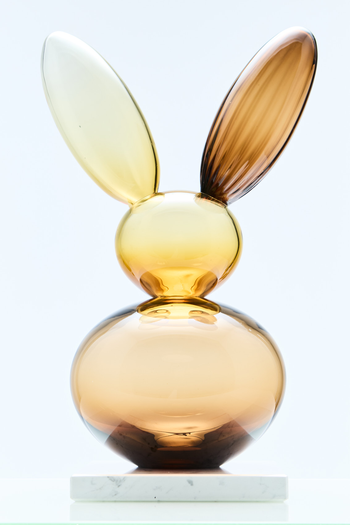 Lasinen pupuveistos marmorijalustalla