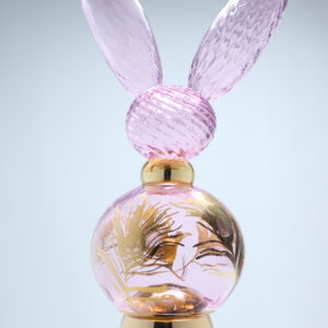 Vaaleanpunainen hajuvesipullo kultaisilla yksityiskohdilla