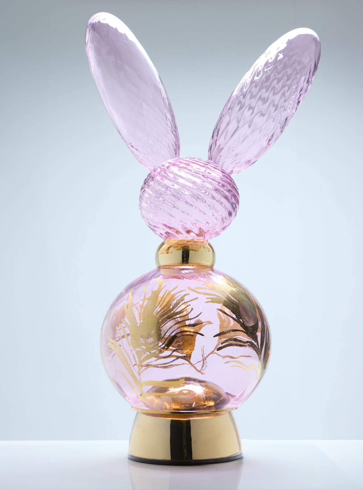 Vaaleanpunainen hajuvesipullo kultaisilla yksityiskohdilla