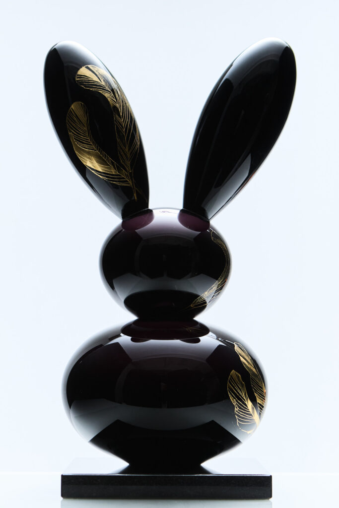 Moderni musta jänispatsas kultaisilla koristeilla