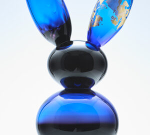 Sininen lasinen kanipatsas kultaisilla yksityiskohdilla.