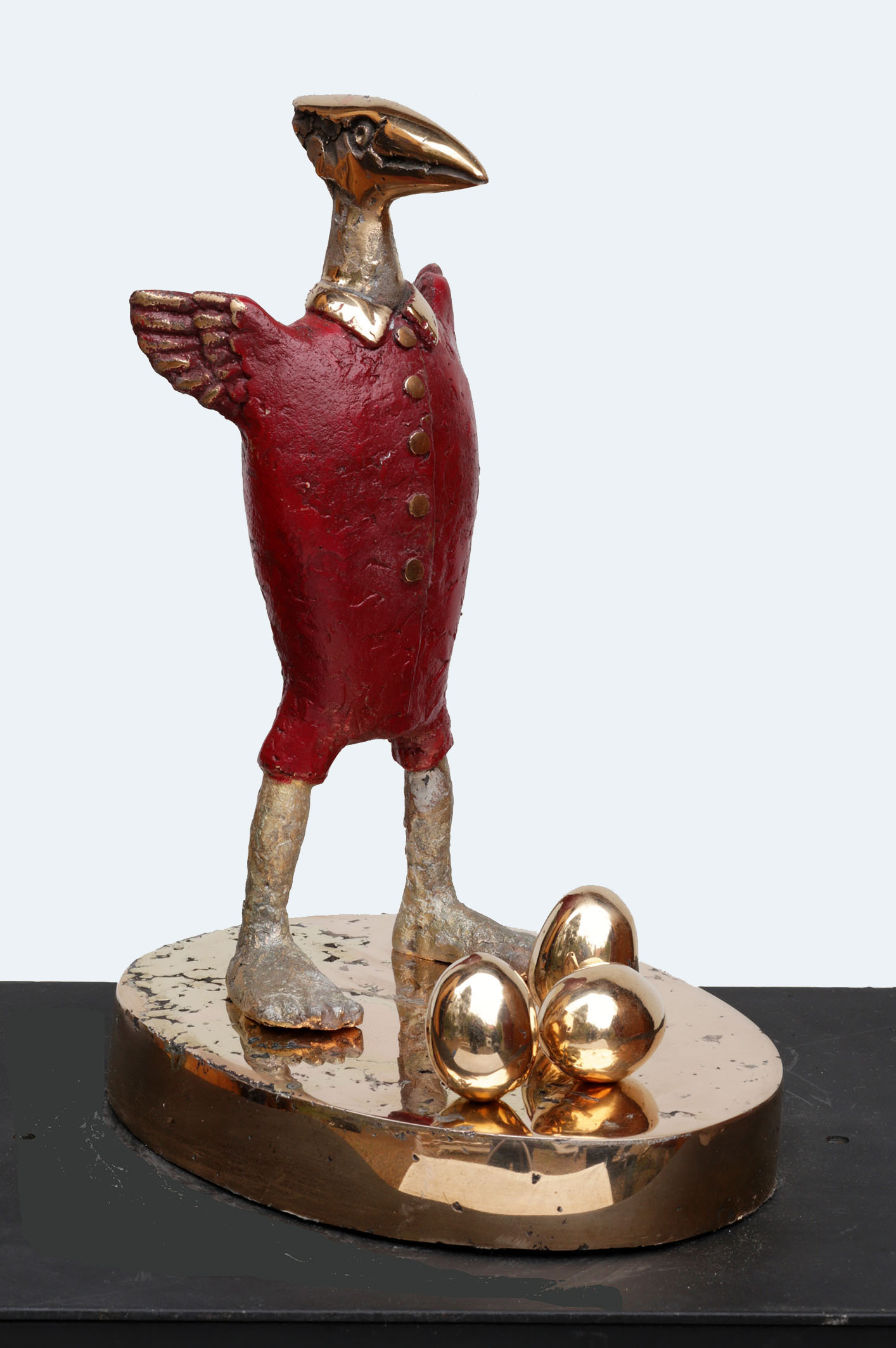 Veistos punaisesta linnusta ja kultamunista.