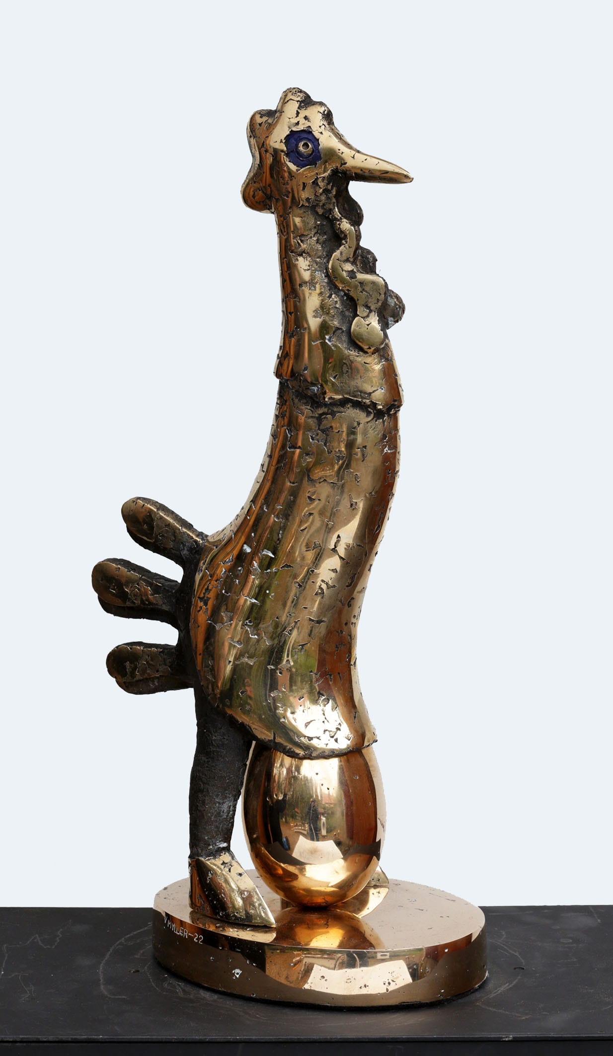 Kultainen abstrakti kukkopatsas modernilla muotoilulla.