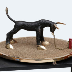 Pieni veistos härästä ketjussa hiekka-alustalla.