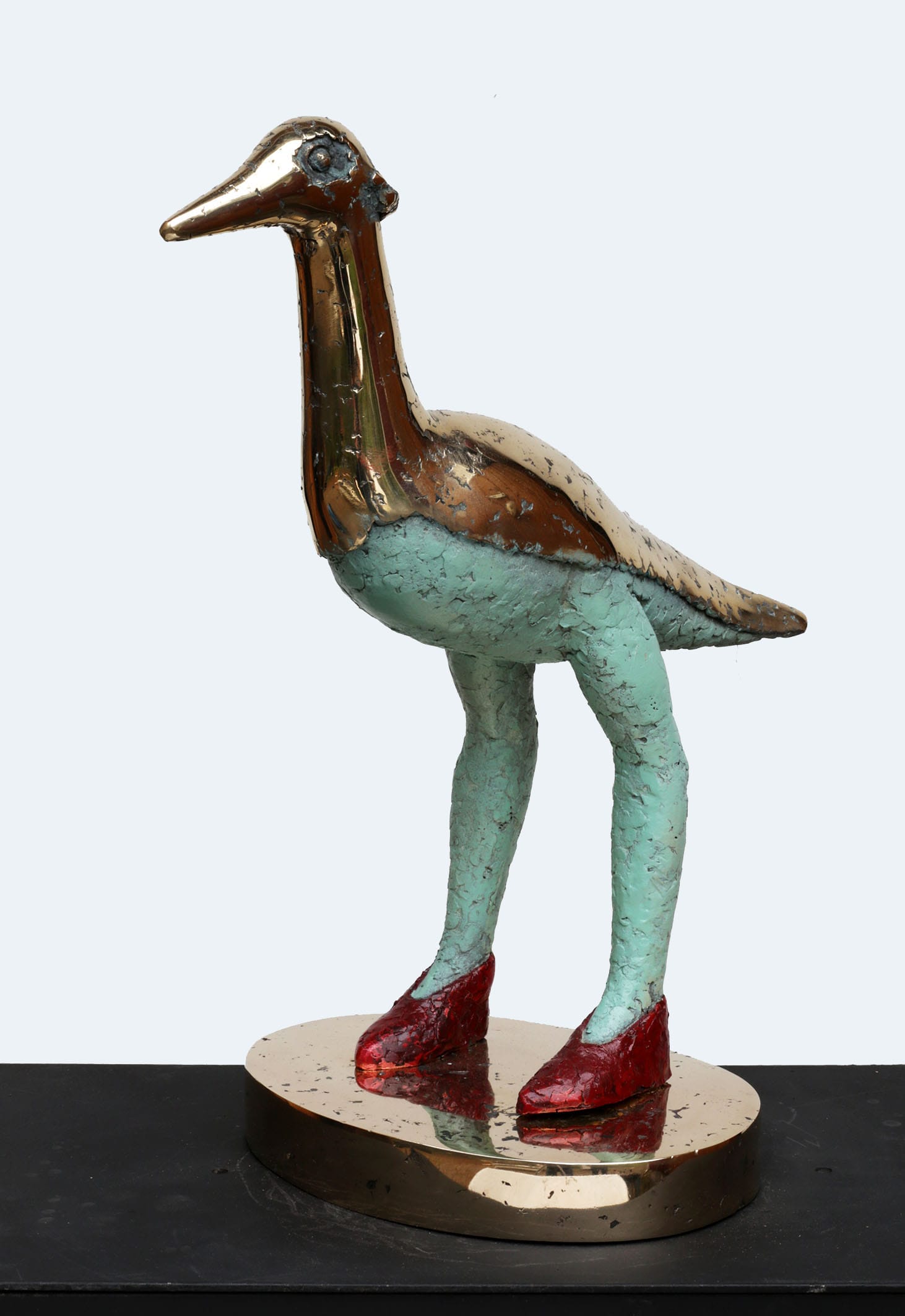 Kuvapatsas linnusta punaisissa kengissä alustalla.