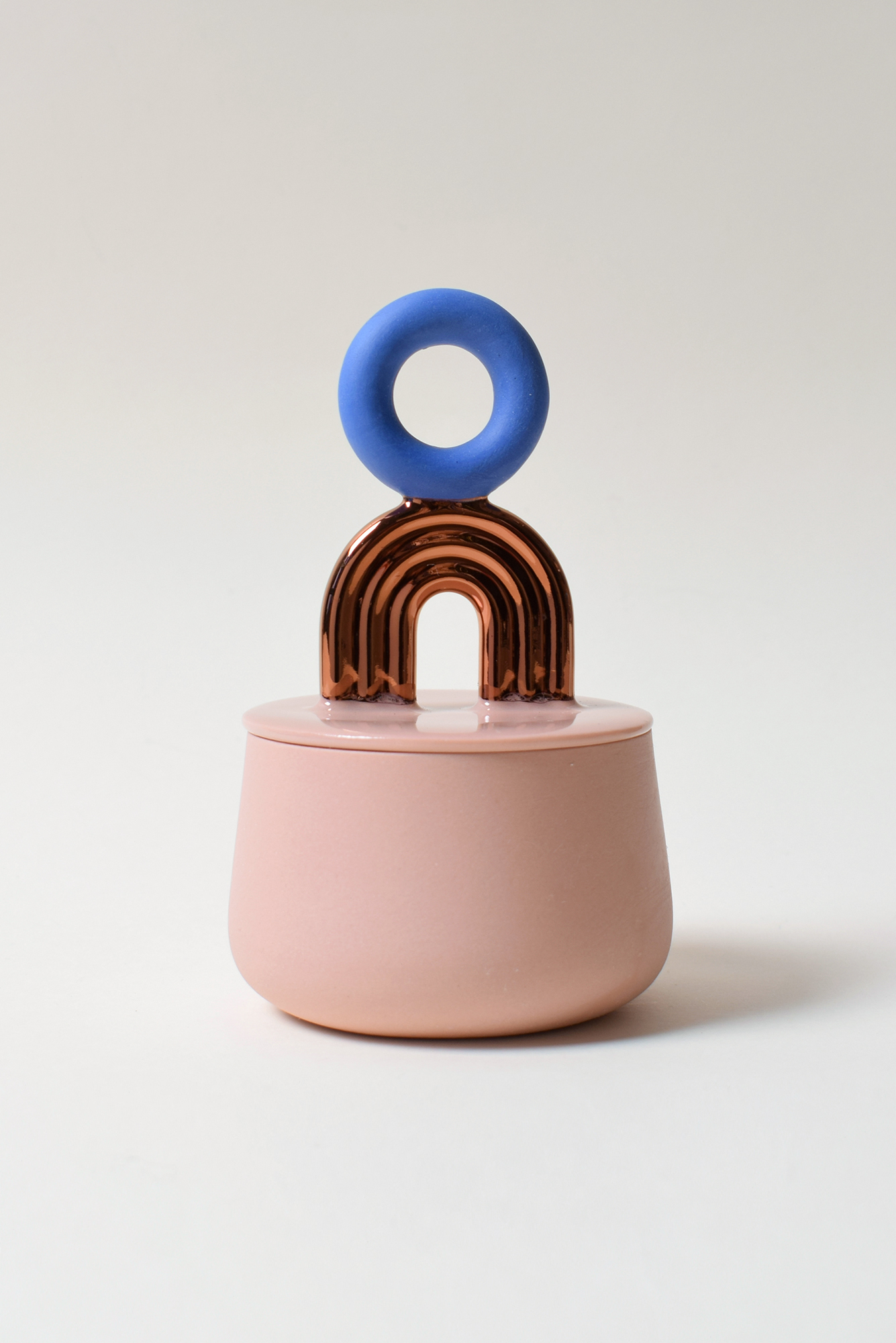 Moderni vaaleanpunainen purkki sinisellä ja kultaisella kannella.