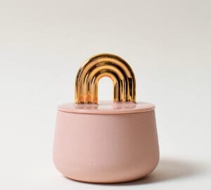 Vaaleanpunainen purkki kultaisella kaarevalla kahvalla