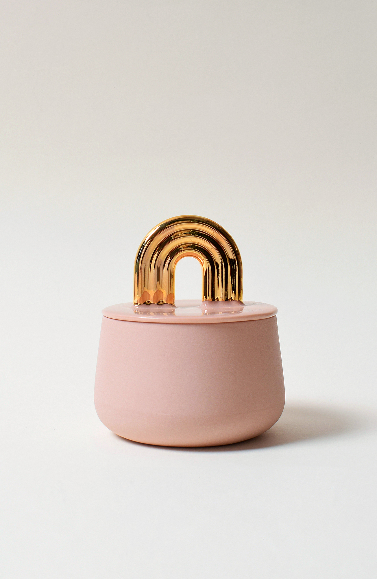 Vaaleanpunainen purkki kultaisella kaarevalla kahvalla