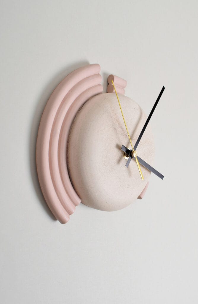 Vaaleanpunainen seinäkello modernilla muotoilulla