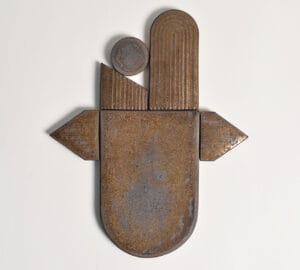 Abstrakti metalliveistos, geometriset muodot, valkoinen tausta.