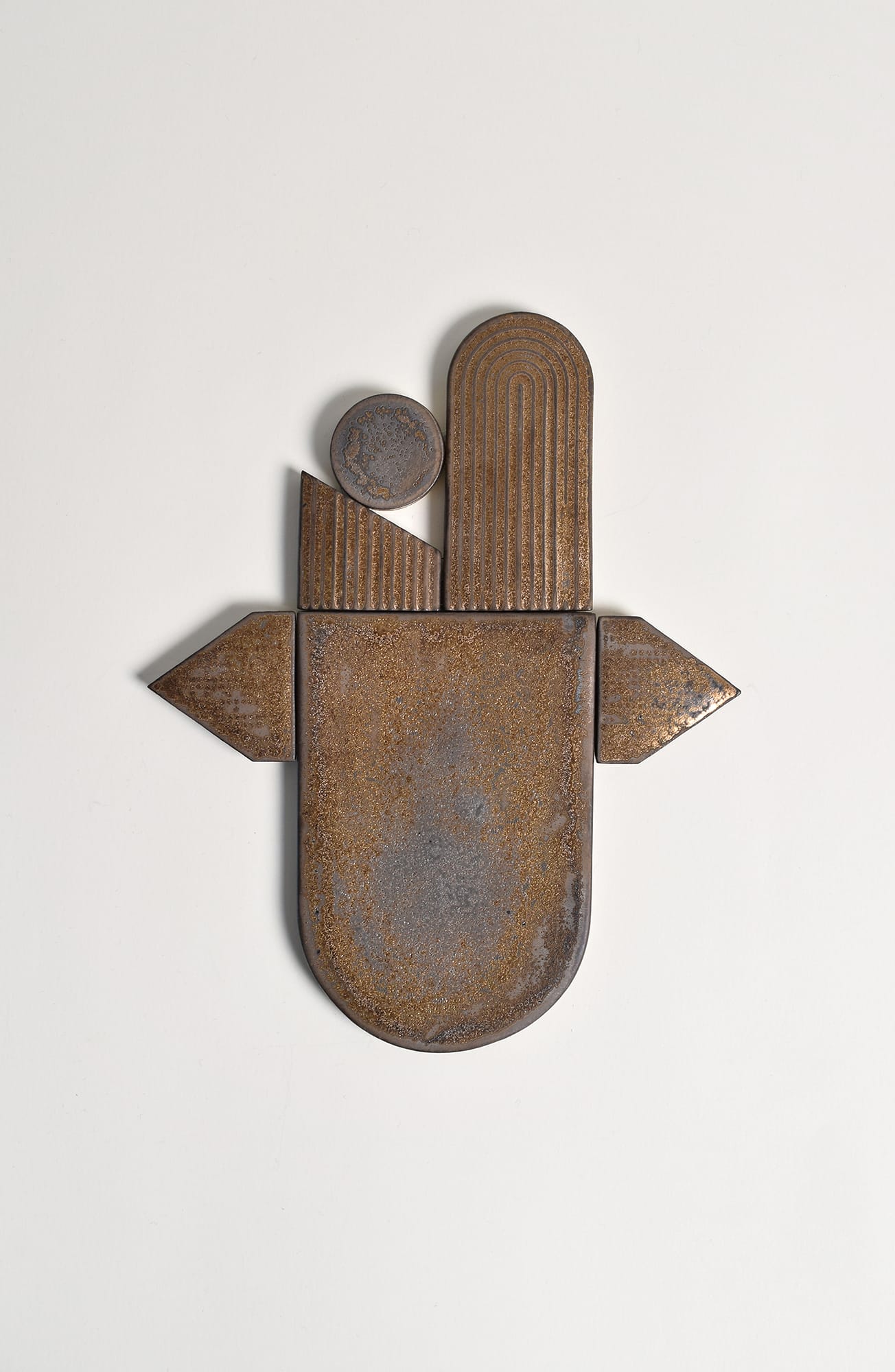 Abstrakti metalliveistos, geometriset muodot, valkoinen tausta.