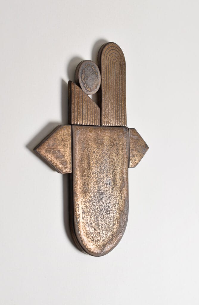 Moderni abstrakti pronssiveistos seinällä