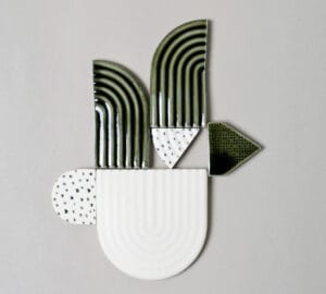 Värikäs geometrinen keramiikkaveistos vaalealla taustalla.