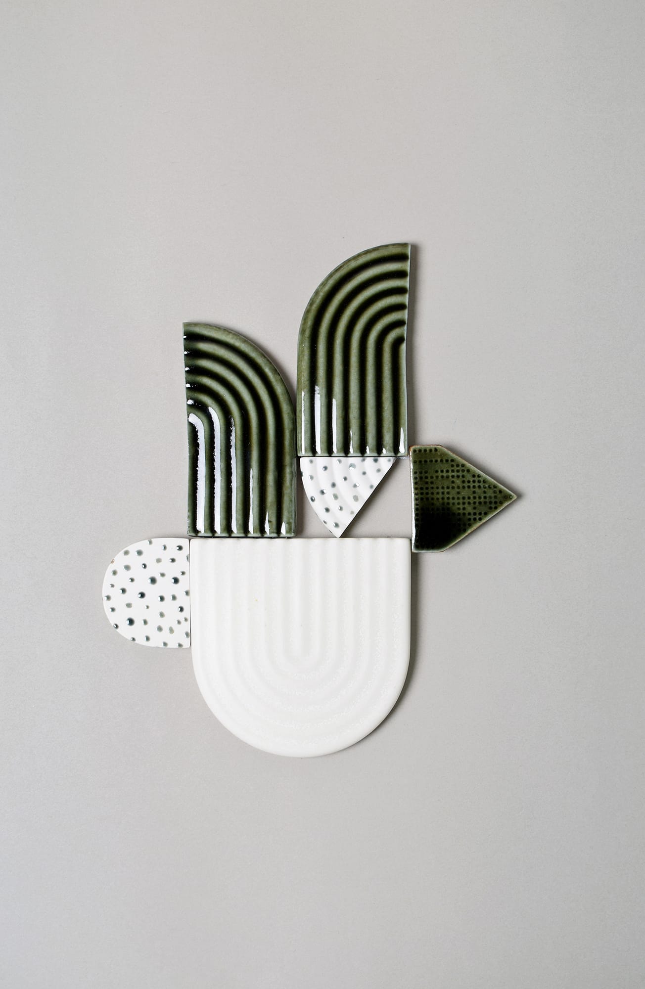 Värikäs geometrinen keramiikkaveistos vaalealla taustalla.