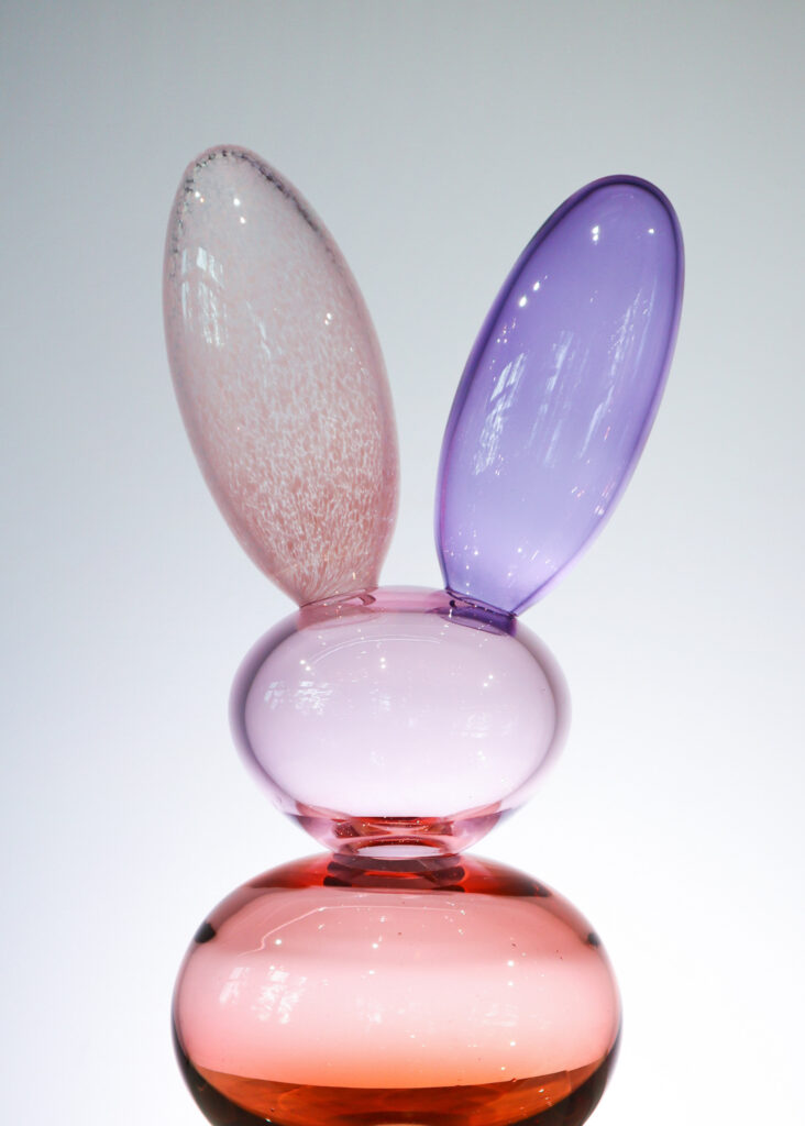 Lasitaideteos vaaleanpunaista ja violettia lasia