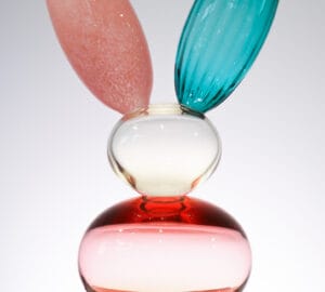 Monivärinen lasiveistos pupun korvilla