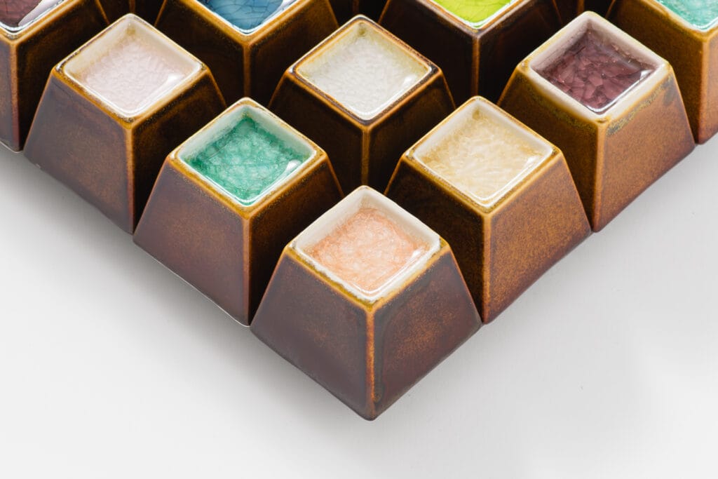 Värikkäät neliömäiset astiat valkoisella taustalla