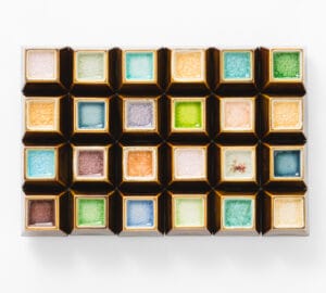 Värikkäät lasimosaiikit valkoisella taustalla.