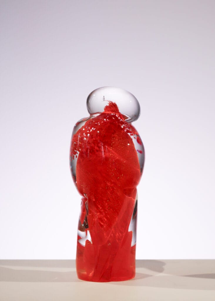 Punainen lasiesine valkoisella taustalla.