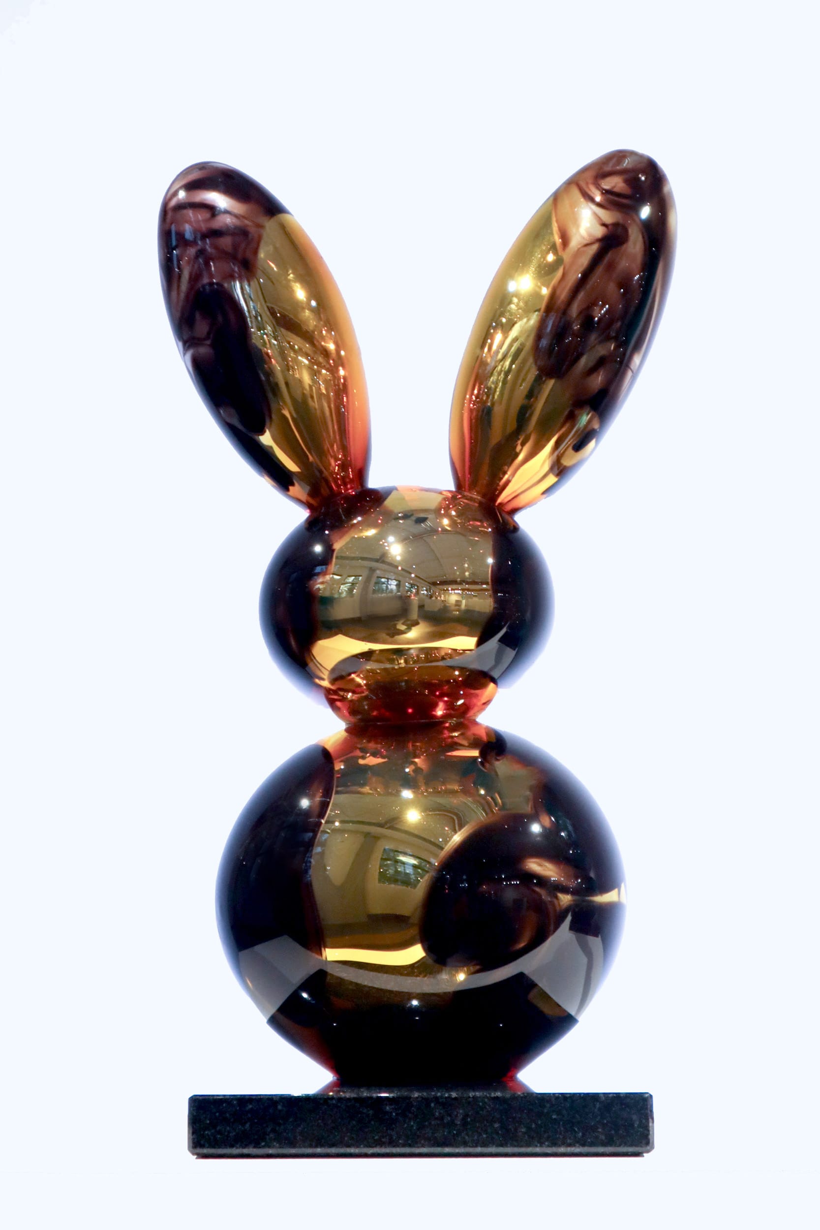 Pronssi kaniveistos kiiltävä mustalla alustalla.