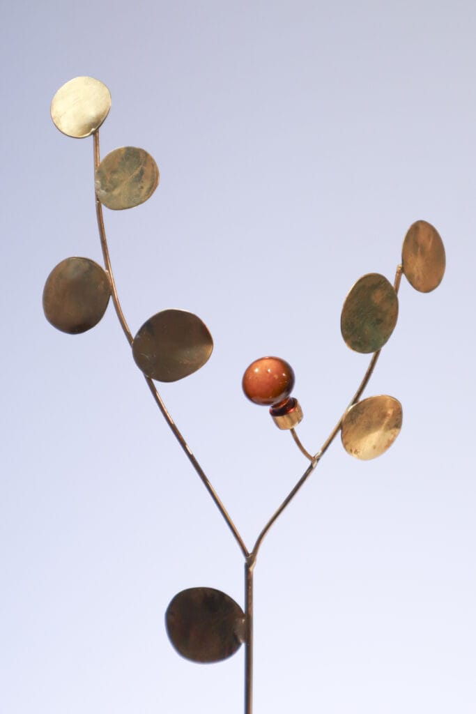 Moderni metalliveistos puun oksista ja hedelmästä