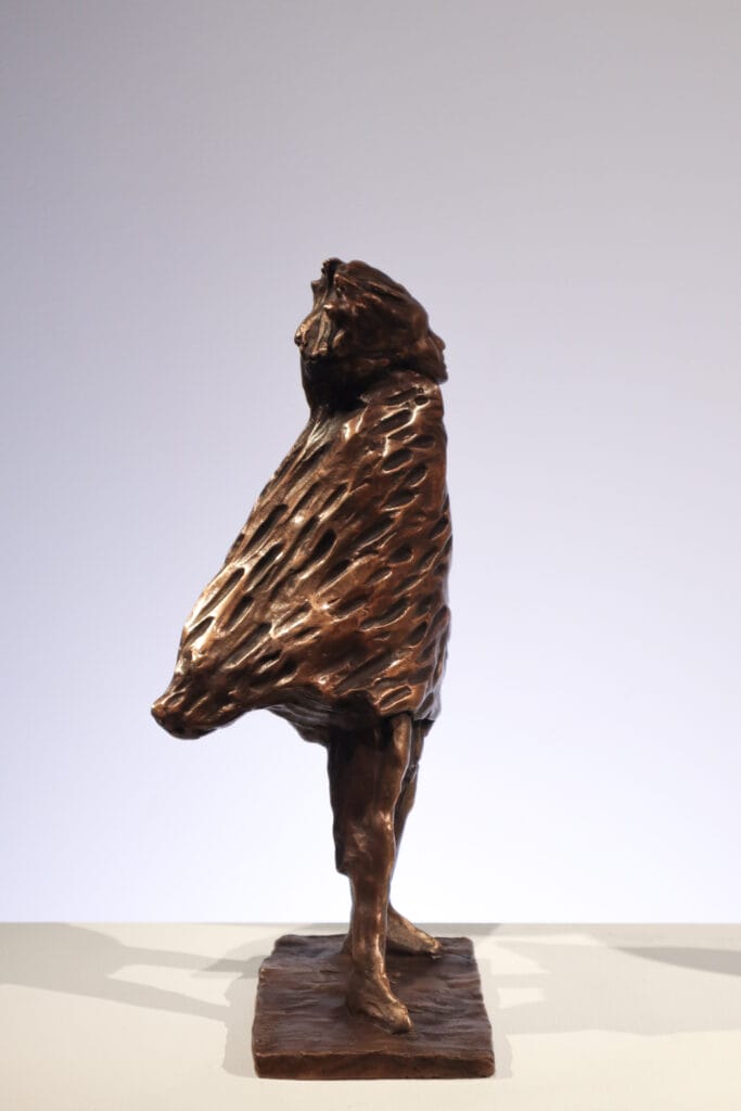 Pronssipatsas henkilö viitan kanssa