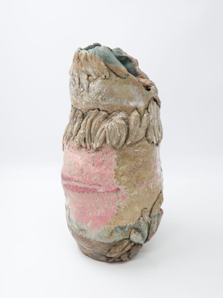 Abstrakti keraaminen veistos vaaleanpunaisilla ja vihreillä sävyillä.