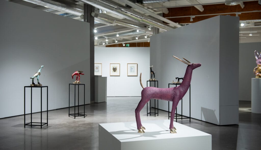 Moderni taidenäyttely, värikkäitä eläinveistoksia esillä.