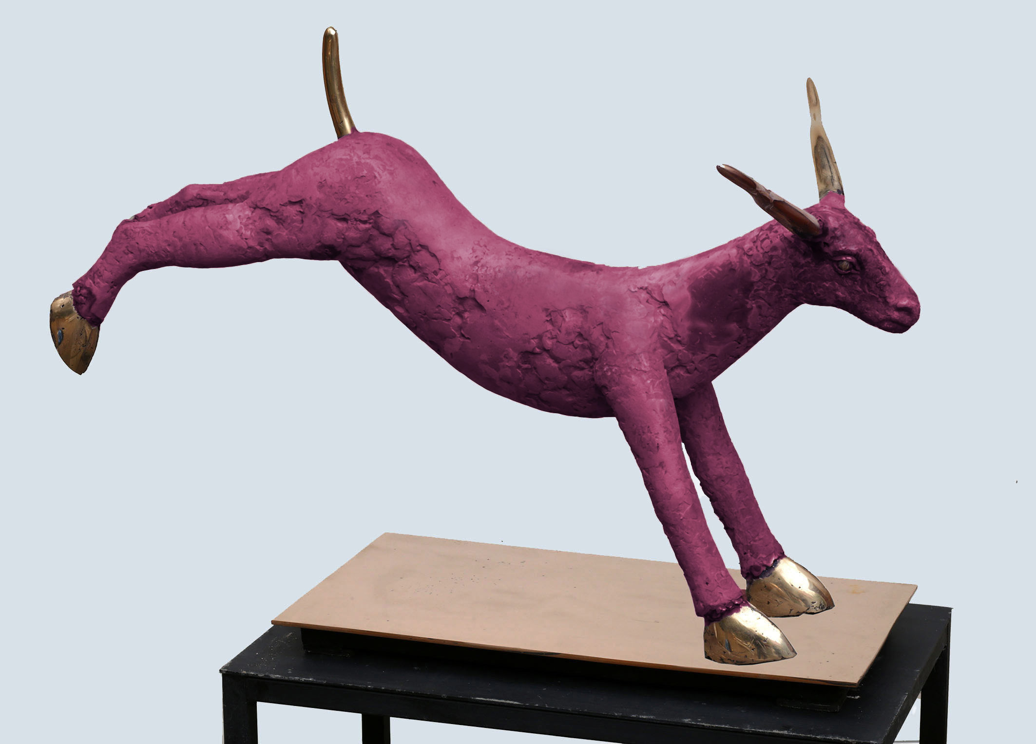 Vaaleanpunainen pukki hyppää alustalta, moderni veistos.