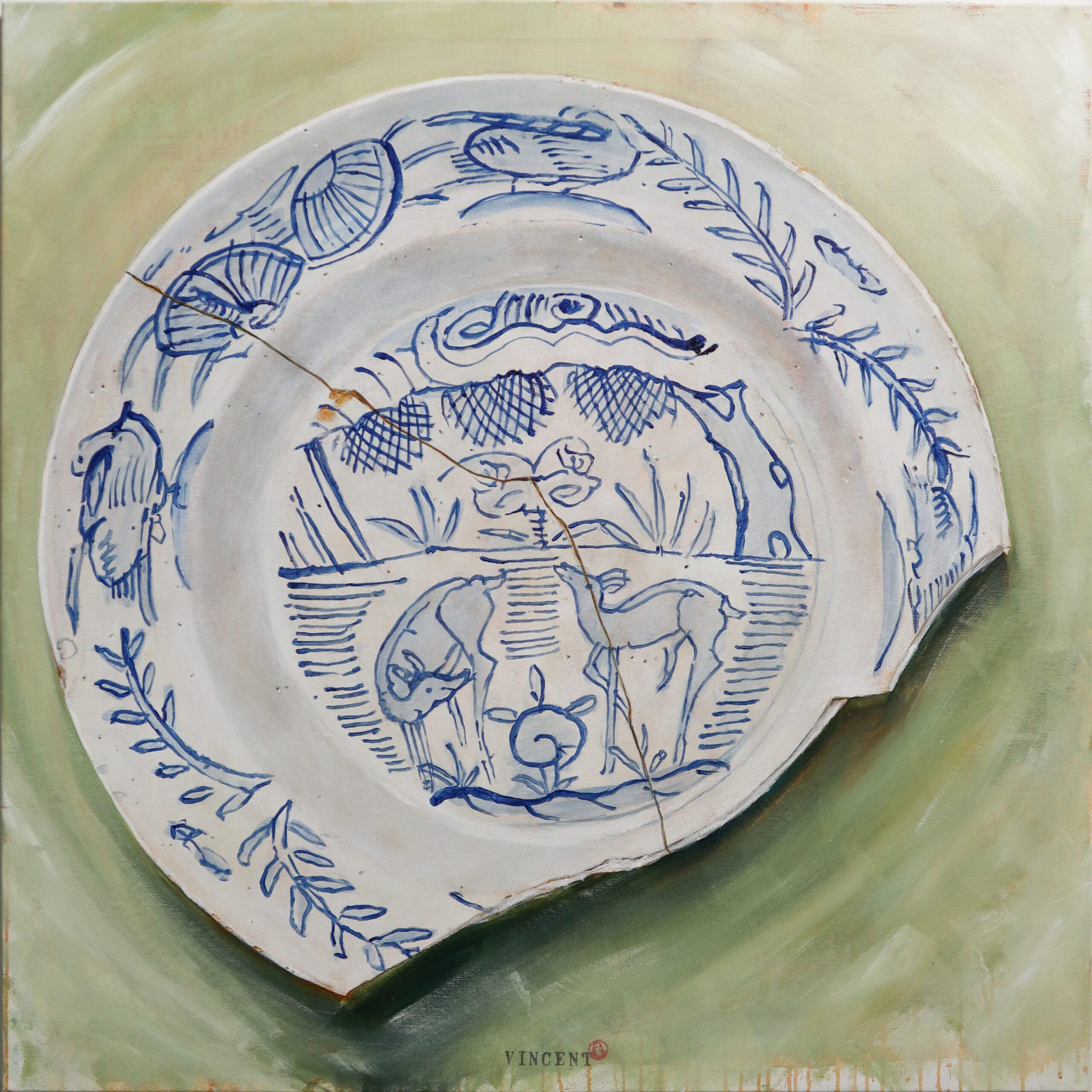 Rikkinäinen posliinilautanen sinisellä kuvioinnilla vihreällä pohjalla.