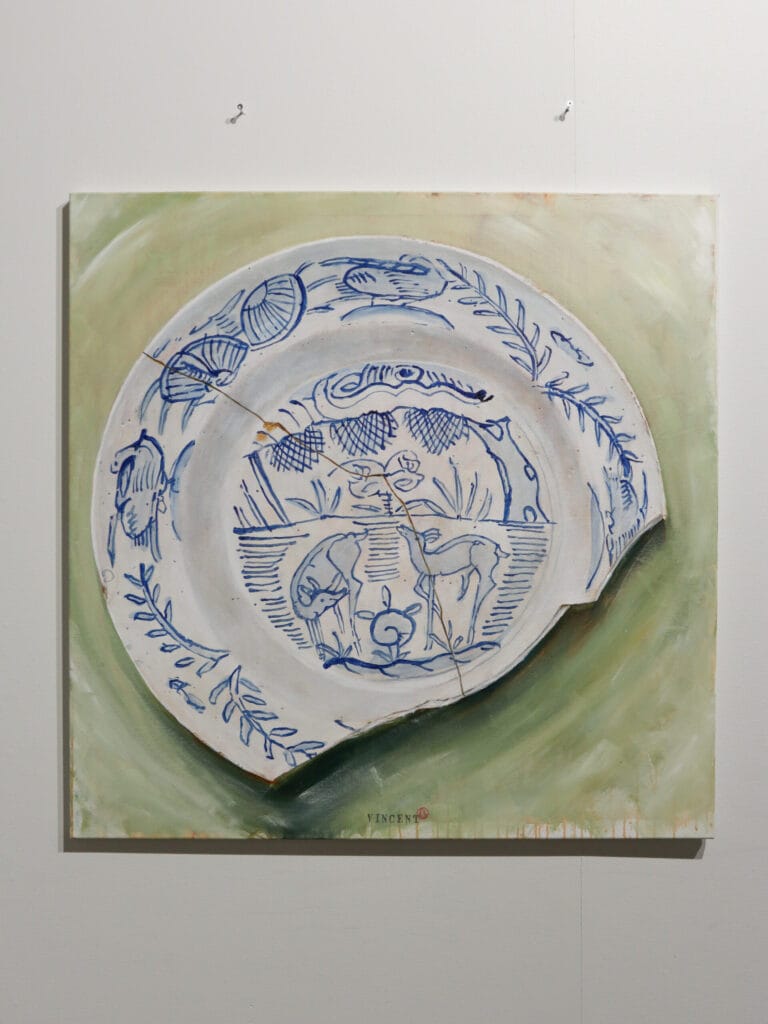 Sinivalkoinen koristeellinen posliinilautanen vaalealla taustalla.