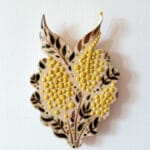 Keraaminen kuva lehtikoristeella ja keltaisilla pisteillä